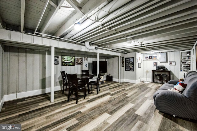 basement with wood-type flooring and wood walls