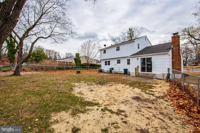 rear view of house featuring a lawn