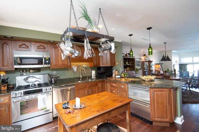 kitchen with sink, dark hardwood / wood-style flooring, kitchen peninsula, appliances with stainless steel finishes, and ornamental molding