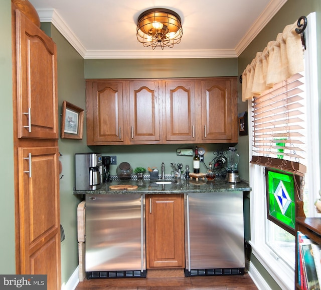 bar featuring stainless steel fridge, dark hardwood / wood-style flooring, dark stone counters, and ornamental molding