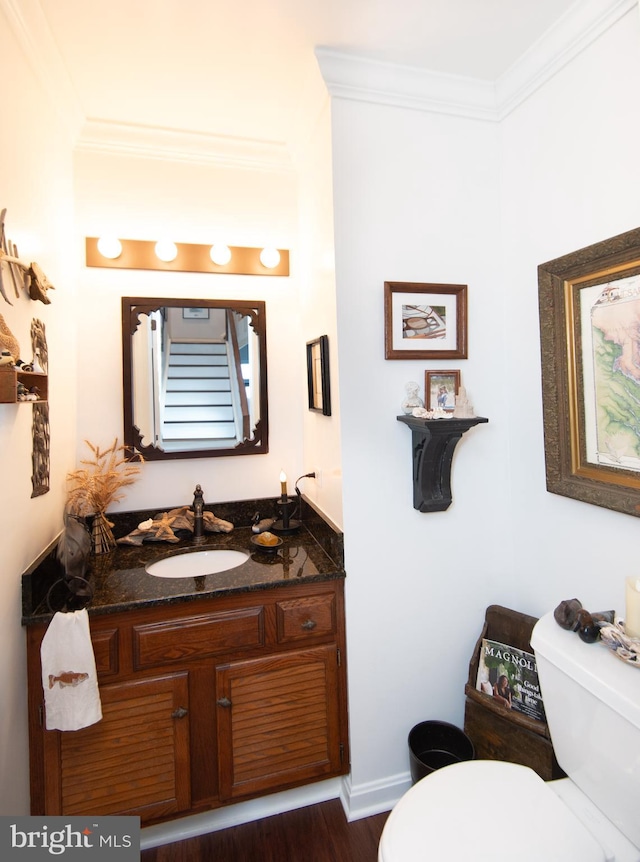 bathroom featuring crown molding, hardwood / wood-style floors, vanity, and toilet