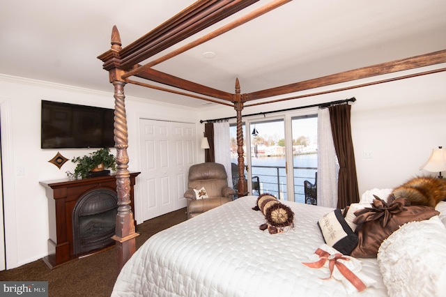 carpeted bedroom featuring beamed ceiling, crown molding, access to outside, a closet, and a water view