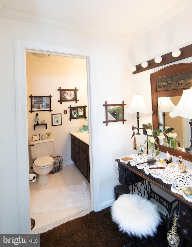 bathroom featuring toilet, vanity, and ornamental molding