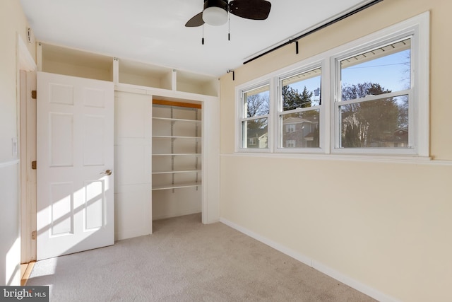 unfurnished bedroom with ceiling fan, a closet, and light carpet