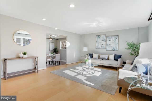 living room with ceiling fan and light hardwood / wood-style floors