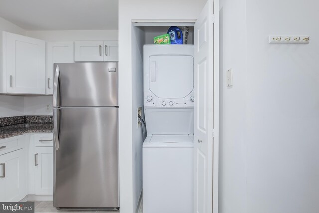 clothes washing area with stacked washer and clothes dryer