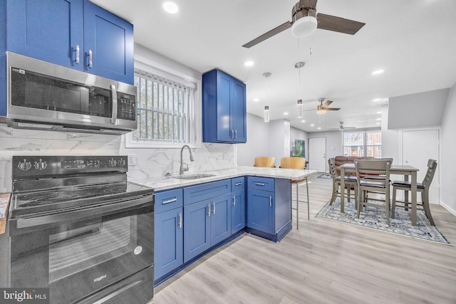 kitchen with a breakfast bar, sink, light hardwood / wood-style flooring, electric range, and kitchen peninsula