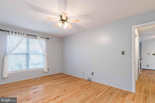 spare room with ceiling fan and light wood-type flooring