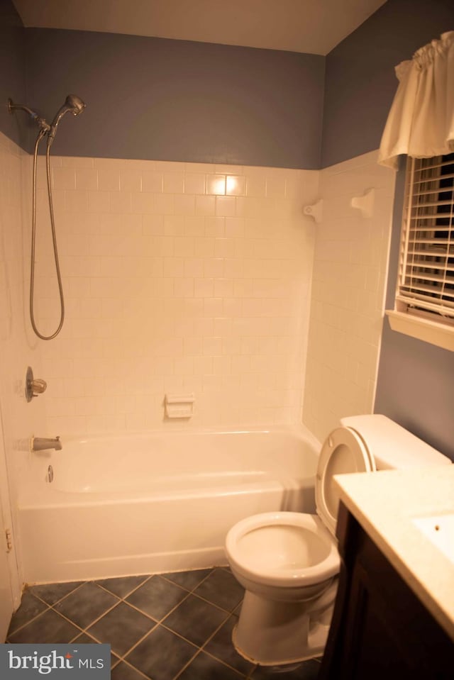 full bathroom featuring tile patterned flooring, vanity, toilet, and tiled shower / bath