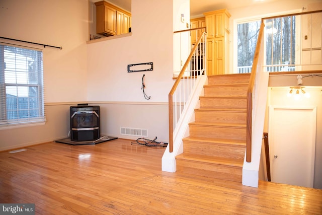 stairway featuring wood-type flooring and a wood stove