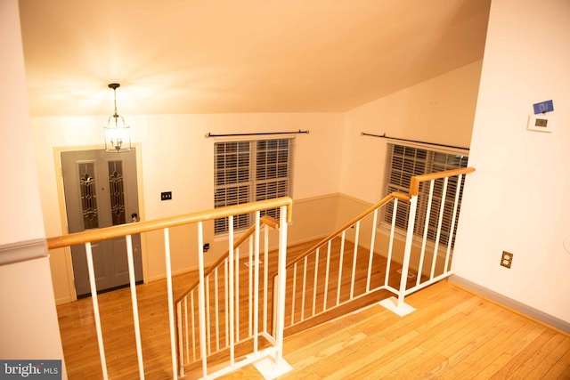 stairs with french doors, a chandelier, and wood-type flooring