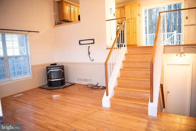 stairs with a wood stove and hardwood / wood-style floors