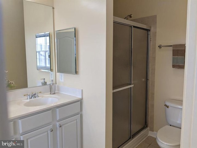 bathroom featuring a shower with door, vanity, tile patterned floors, and toilet