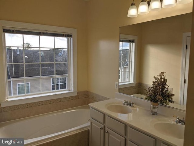 bathroom featuring vanity, a wealth of natural light, and tiled bath