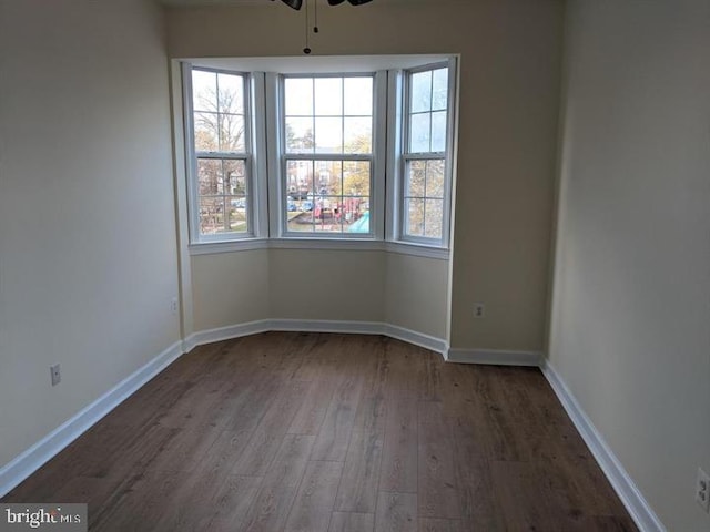 empty room featuring dark wood-type flooring and ceiling fan