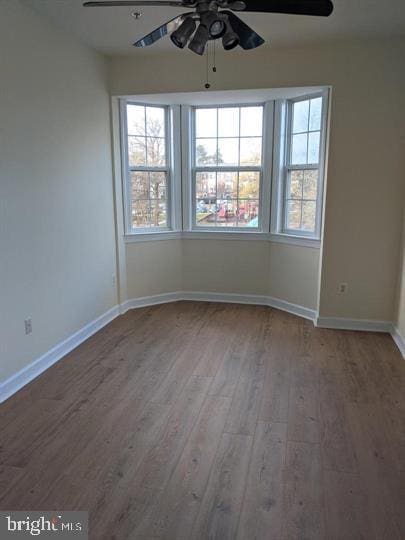 unfurnished room with ceiling fan and wood-type flooring