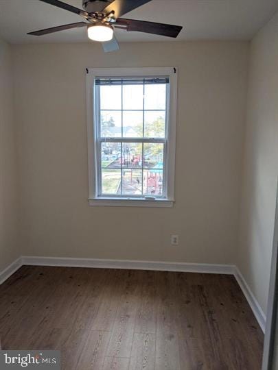 empty room with ceiling fan and dark hardwood / wood-style floors