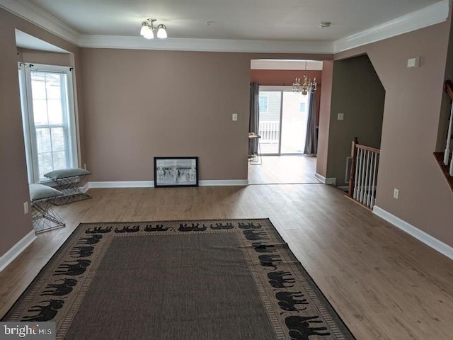 interior space with wood-type flooring, crown molding, and a chandelier