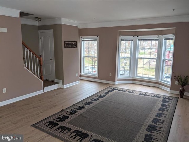 interior space with ornamental molding and light hardwood / wood-style floors