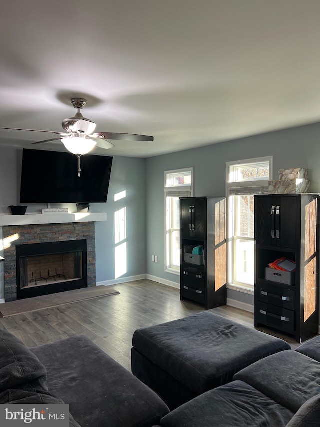 living room featuring a fireplace, a wealth of natural light, dark hardwood / wood-style flooring, and ceiling fan