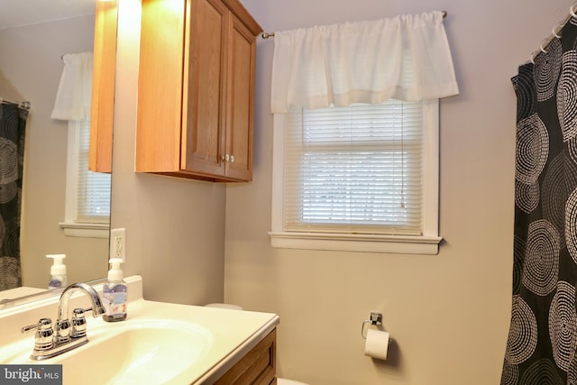 bathroom featuring vanity, toilet, and plenty of natural light