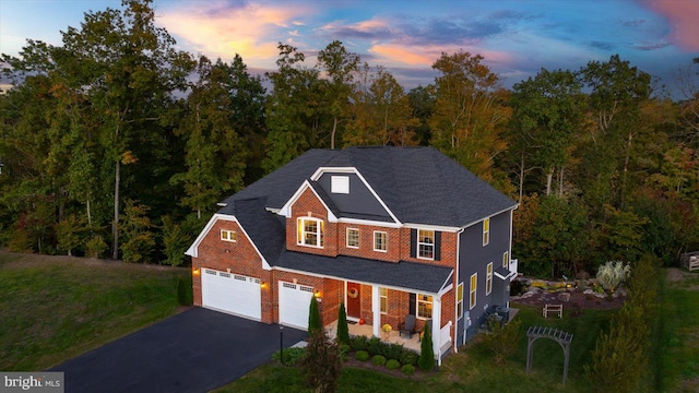 view of front of property featuring a lawn, a porch, and a garage