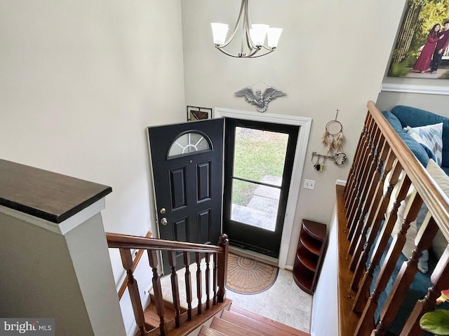 foyer entrance with hardwood / wood-style flooring and a notable chandelier