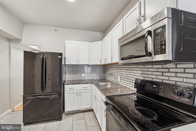 kitchen featuring sink, white cabinets, black appliances, and light tile patterned floors