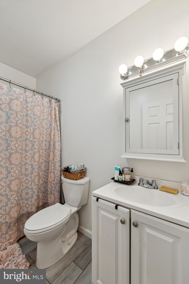 bathroom featuring hardwood / wood-style flooring, vanity, and toilet