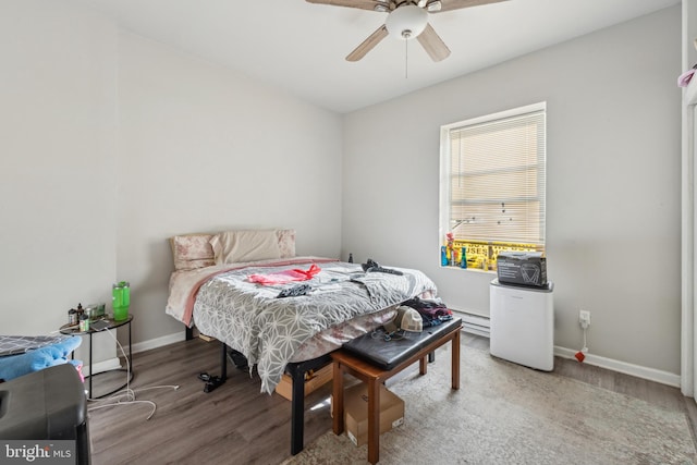 bedroom with hardwood / wood-style floors, ceiling fan, and baseboard heating