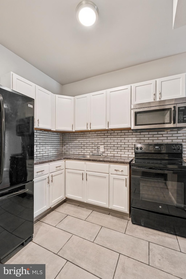 kitchen with black appliances, decorative backsplash, and white cabinets