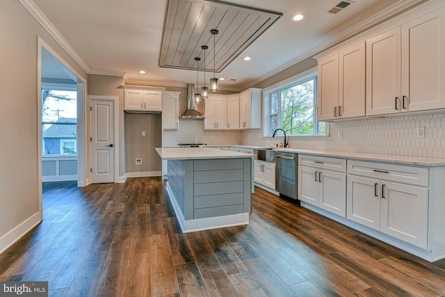 kitchen with stainless steel dishwasher, white cabinets, wall chimney range hood, and hanging light fixtures