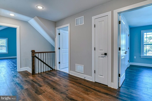 hall featuring lofted ceiling and dark hardwood / wood-style floors