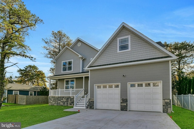 craftsman house with a porch, a front yard, and a garage