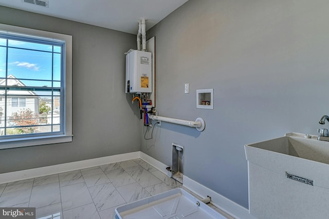 clothes washing area with hookup for a washing machine, tankless water heater, and sink