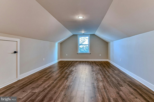 bonus room with dark hardwood / wood-style floors and vaulted ceiling