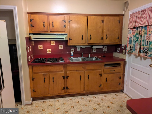 kitchen featuring decorative backsplash, stainless steel gas cooktop, and sink