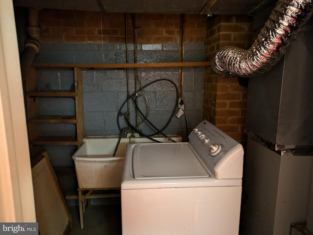 clothes washing area featuring sink and washer / clothes dryer