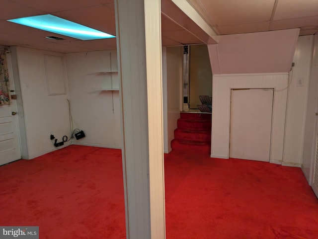 basement with carpet floors and a drop ceiling