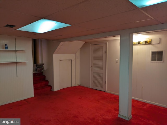 basement with carpet floors and a drop ceiling