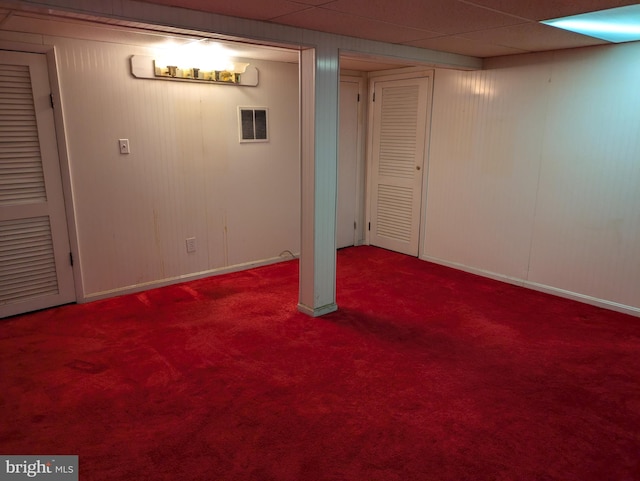 basement featuring carpet and a drop ceiling