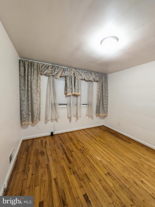 empty room with hardwood / wood-style flooring