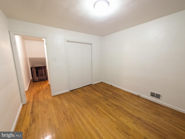 unfurnished bedroom featuring light hardwood / wood-style flooring and a closet