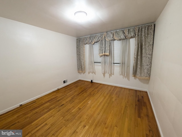 spare room with hardwood / wood-style floors