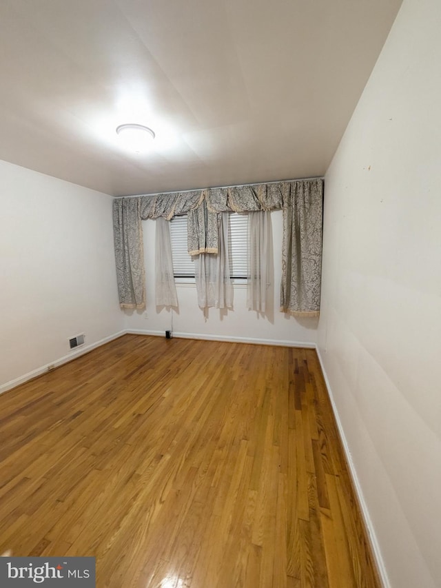 unfurnished room featuring hardwood / wood-style flooring