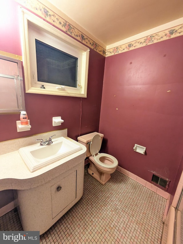 bathroom with tile patterned flooring, vanity, and toilet