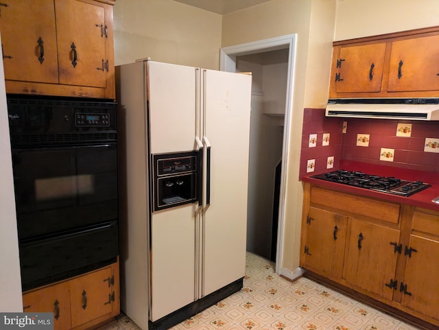 kitchen with ventilation hood, decorative backsplash, white fridge with ice dispenser, black oven, and gas cooktop