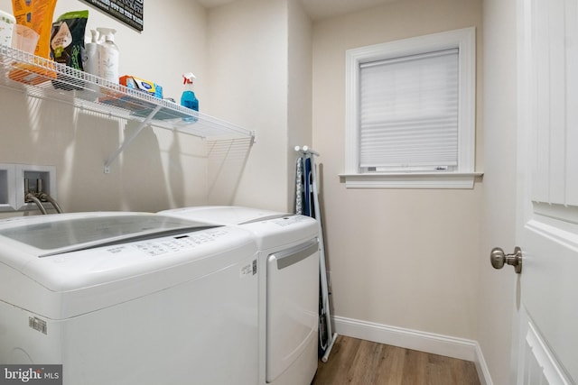 laundry room featuring wood-type flooring and separate washer and dryer