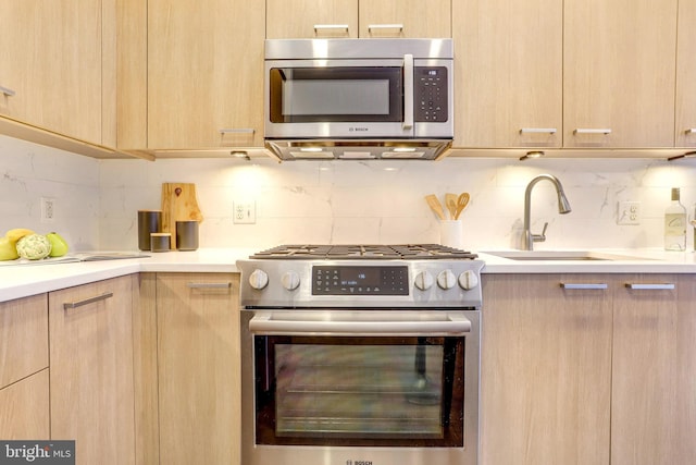 kitchen featuring decorative backsplash, sink, stainless steel appliances, and light brown cabinetry