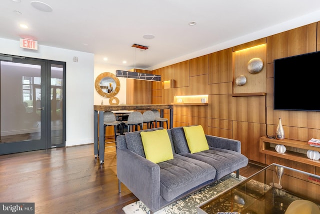 living room featuring wood walls and dark hardwood / wood-style floors